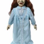 Sweet dreams? Not tonight! Straight from the 1973 horror classic, Regan MacNeil has arrived and is the perfect companion for a sinister slumber party! The devil is in the details! Regan is outfitted in her signature blue nightgown and features hauntingly life-like features that capture her demonic expression - yellowed eyes, cracked skin, and a devilish grin. She is approximately 18" tall (46 cm) and features sculpted parts on a soft plush body. This cuddly conduit of evil is ideal for someone who enjoys sleeping with the lights on and keeps a bottle of holy water under their pillow. The MDS Roto Plush The Exorcist comes packaged in a die-cut window box, perfect for display. WARNING: May cause spontaneous crucifix flipping.